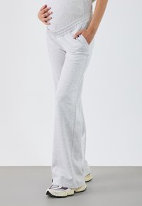 Graue Umstands-Sweatpants mit weitem Beinansatz, elastischem Bund und seitlichen Taschen. Hergestellt aus weichem, atmungsaktivem Material.