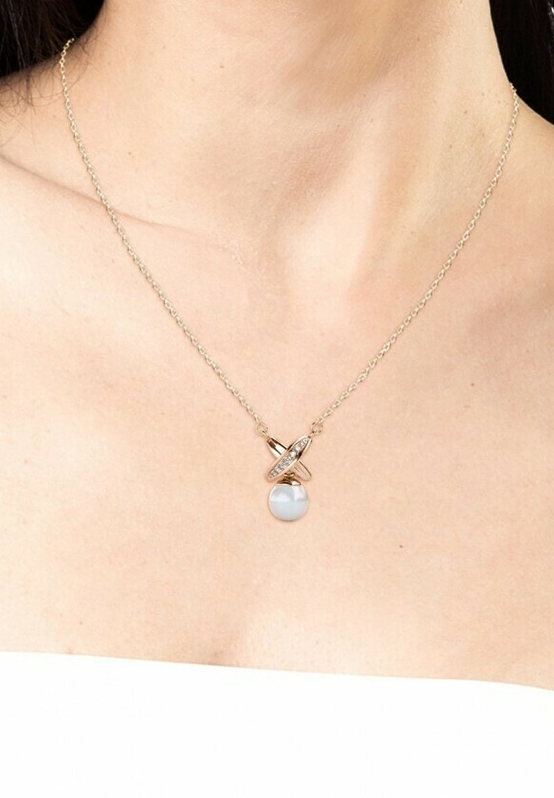 Collana in tono oro con anelli intrecciati, caratterizzata da un pendente circolare con gemma bianca. I collegamenti della catena sono delicati e uniformemente distanziati.