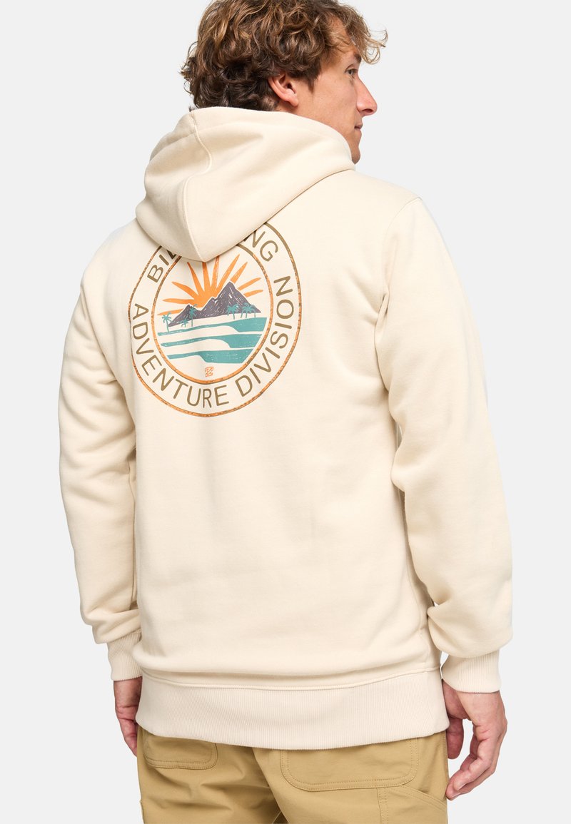 Sudadera beige hecha de tela suave con un logo en la parte posterior que presenta montañas y un sol, acentuado en naranja y verde.