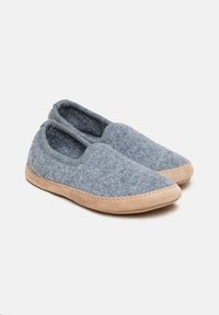 Grå filt hjemmesko med en tan ruskindssål, elastiske åbninger og syede detaljer langs kanterne. Glat tekstur og slip-on design.