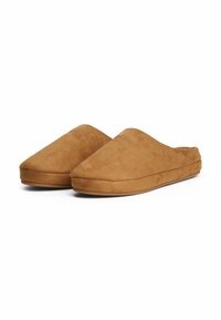 Ein Paar braune Wildleder-Slipper mit geschlossenen Zehen und gepolsterter Sohle auf weißem Hintergrund.