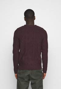 Burgunderfarbener Strickpullover mit einem strukturierten Muster, gerippten Bündchen und Saum, Rundhalsausschnitt und langen Ärmeln. Rückansicht gezeigt.