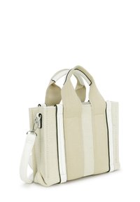 Kleine beige und weiße Stoffhandtasche mit zwei kurzen Griffen und einem abnehmbaren weißen Schultergurt auf einem weißen Hintergrund.