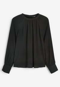 Blusa nera a maniche lunghe con scollatura tonda e dettagli arricciati. Presenta un tessuto texturizzato con piccole pois e polsini affusolati.
