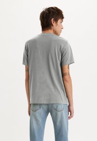 Grå kortærmet t-shirt med rund hals, lavet af blødt stof, der har en afslappet pasform og minimal syningsdetalje.