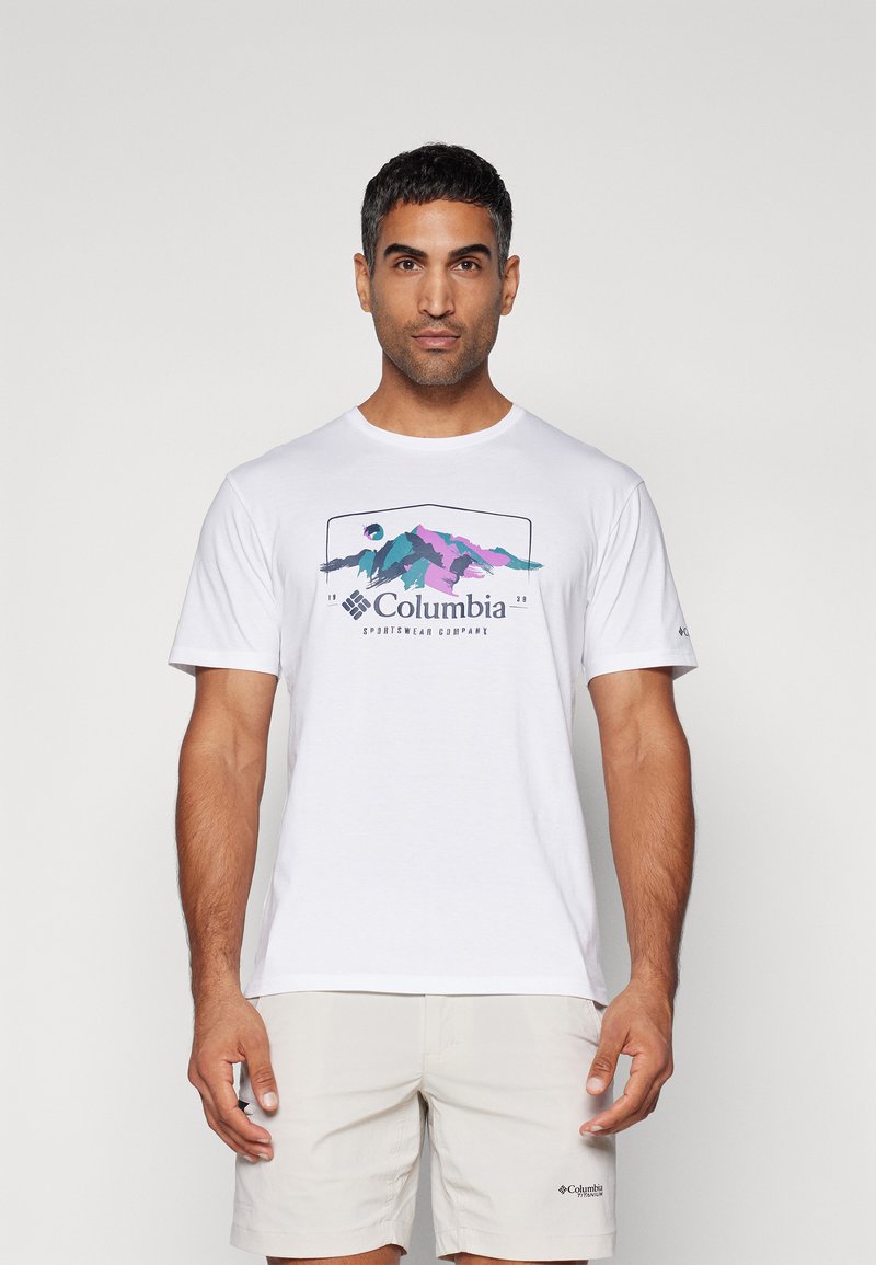 Valkoinen lyhythihainen t-paita, jossa on värikäs vuoristografiikka ja "Columbia Sportswear Company" -teksti keskellä.