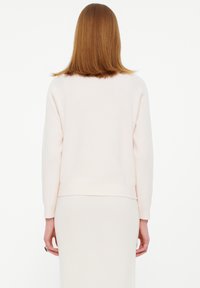 Helles rosa geripptes Sweatshirt mit langen Ärmeln, Rundhalsausschnitt und geradem Schnitt. Ausgestattet mit einer weichen Textur und einem lockeren Sitz.