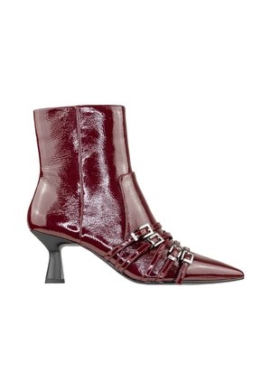 Stivale alla caviglia in pelle patent color bordeaux con punta affusolata, tacco stiletto sottile e diverse cinghie con fibbie argentate sulla parte anteriore. Texture liscia.