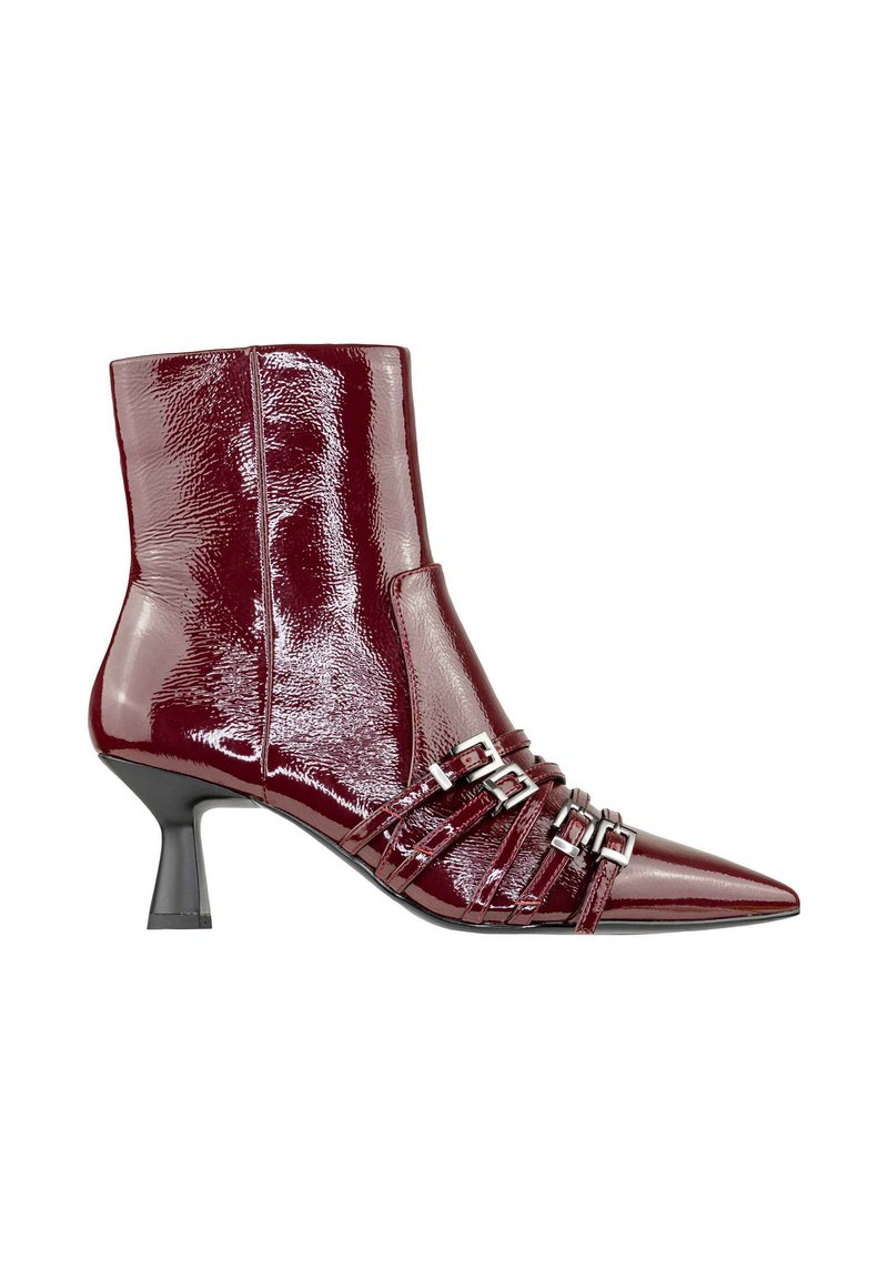 Stivale alla caviglia in pelle patent color bordeaux con punta affusolata, tacco stiletto sottile e diverse cinghie con fibbie argentate sulla parte anteriore. Texture liscia.