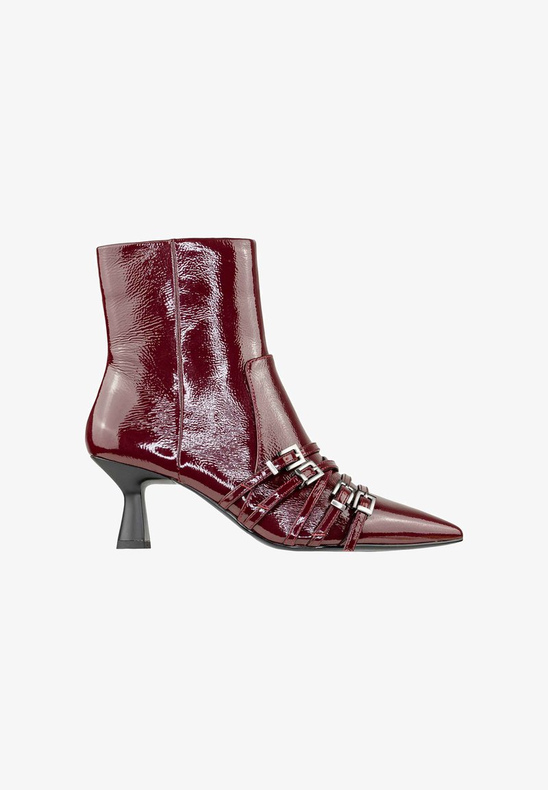 Stivale alla caviglia in pelle patent color bordeaux con punta affusolata, tacco stiletto sottile e diverse cinghie con fibbie argentate sulla parte anteriore. Texture liscia.