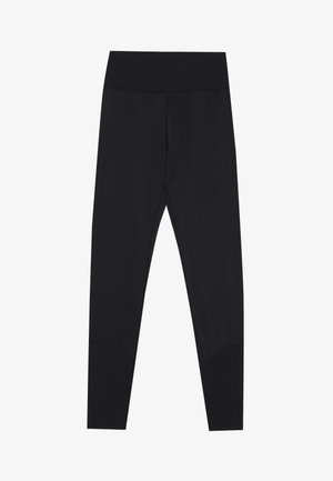 Svarta leggings med ett brett ribbat midjeband, slät textur och en figurnära design. De sträcker sig till anklarna och har en sömlös finish.