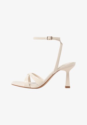 Béžové sandály na vysokém podpatku s otevřenou špičkou, s křížovými popruhy, páskem na kotníku se sponou a silným podpatkem. Hladký povrch.