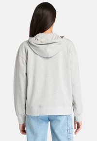 Sweat à capuche gris clair en mélange de coton, présentant une coupe décontractée, des poignets côtelés et une poche kangourou à l'avant.