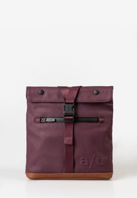 Bordeauxfarbener Rucksack mit gerolltem Oberteil, verstellbarem Tragegurt, schwarzem Reißverschluss und braunem Boden. Mit Logo und Druckknopfverschluss. Strukturierte Oberfläche.