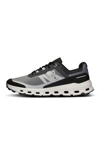Chaussure de sport grise et noire avec une semelle blanche amortie comportant plusieurs découpes hexagonales, logo latéral et lacets noirs sur fond blanc.