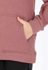 Maroon sweatshirt with a kangaroo pocket, ribbed cuffs, and hem, made of soft fabric with a textured finish, showcasing a relaxed fit.