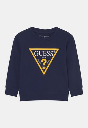 Sweatshirt bleu marin cu un logo mare triuncular galben cu textul "GUESS®" și "U.S.A." , cu manșete și guler ribbă, textură netedă.