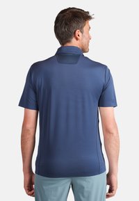 Mörkblå kortärmad polo t-shirt med texturerad krage och slät tyg. Har en avslappnad passform och subtila sidoseams.