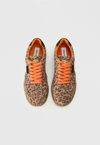 Baskets imprimé léopard avec accents en daim marron, lacets orange et intérieur rembourré. Étiquette signature visible à l'intérieur.