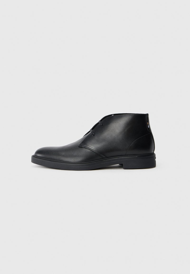 Sorte svart lær ankelstøvler med en jevn tekstur, rund tå, minimalistisk design og en lav, solid gummisåle. Dekorativ syddetalj.