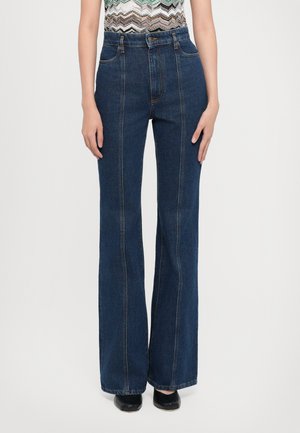 Jean taille haute bleu foncé avec des jambes larges, présentant des poches avant et arrière, des coutures visibles et une texture en denim lisse.