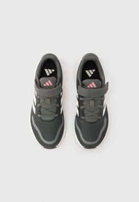 Μαύρα αθλητικά παπούτσια με γκρι επάνω μέρος από δίχτυ και λευκές ρίγες. Λουράκι με βέλκρο και ροζ λεπτομέρεια στη φτέρνα. Στρογγυλεμένη μύτη και λαστιχένια σόλα.