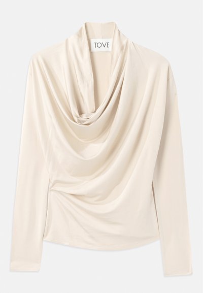 Beige top met lange mouwen, ontwerp met een kraag en een zachte, gladde textuur. Vastgezet in de taille met subtiele geplooide details.