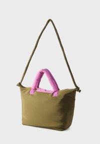 Zöld anyagtáska rózsaszín párnázott fogóval és vállpánttal. Cipzáras záródással és sima, matt felülettel rendelkezik.