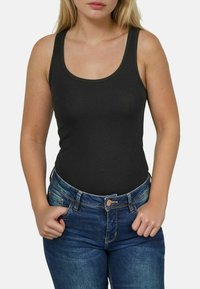 Zwarte tanktop met een ronde hals, gemaakt van een zachte stof, gecombineerd met blauwe denim jeans met een klassieke pasvorm en voorzakken.