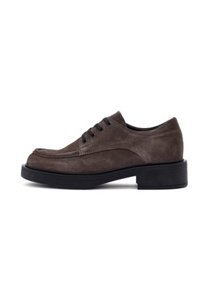 Scarpa in suede marrone con lacci, punta rotonda e suola in gomma nera. Presenta cinque occhielli e una finitura strutturata. Design minimalista.