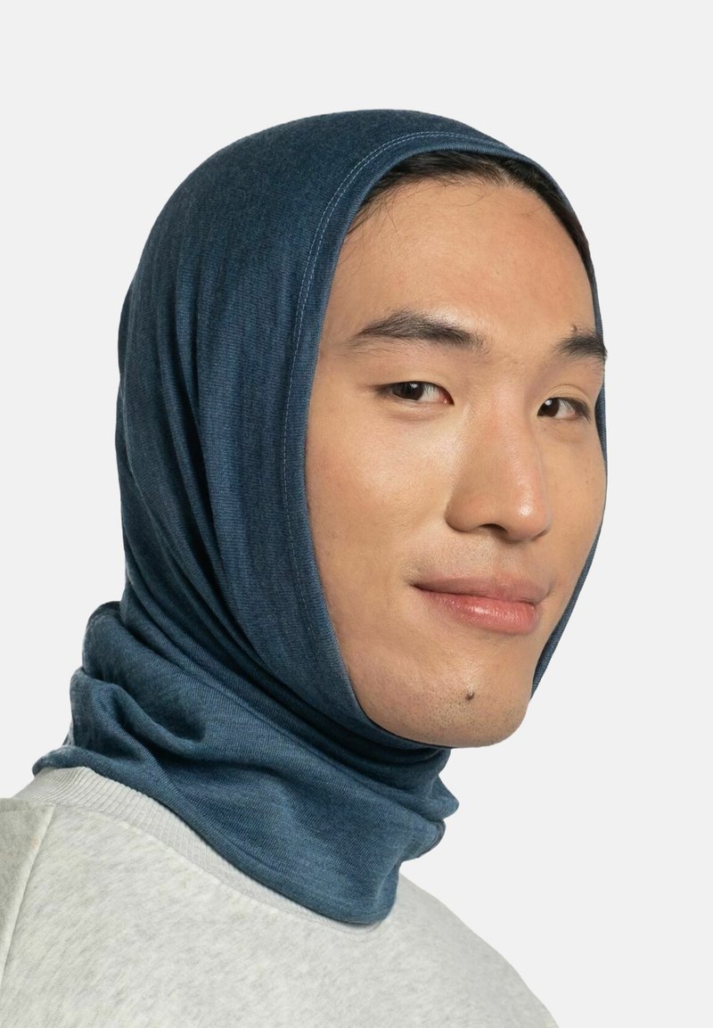 Mann trägt eine blaue, dehnbare Kapuze, die Kopf und Nacken bedeckt, lächelt leicht vor einem schlichten hellen Hintergrund.