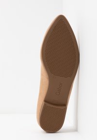 Semelle d'une chaussure pointue beige avec motif ondulé, taille 4½, de marque "Gabor" et indiquée "Fabriqué au Portugal".