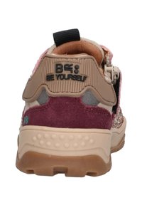 Zapatilla multicolor con tacón de ante burdeos, acentos sintéticos, suela texturizada beige y un logo "Sé tú mismo" en la parte trasera.
