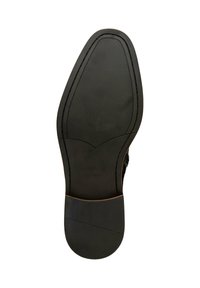 Suela de zapato de cuero negro con un patrón de agarre texturizado, un tacón liso y un diseño de punta redondeada. Marca estampada en el lateral.