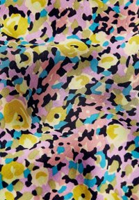 Tessuto di cotone con un motivo astratto multicolore che presenta tonalità di giallo, rosa, nero e teal, realizzato in una trama morbida e testurizzata.