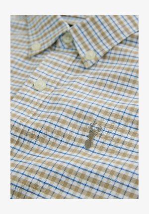 Gombos ing világos barna és kék kockás mintával, puhán tapintású anyagból készült; kis homár hímzéssel díszítve.