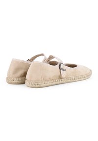 Espadrilles de ante beige con punta redonda, cintas en el tobillo y detalles de yute trenzado en la suela. Textura suave con un diseño minimalista.