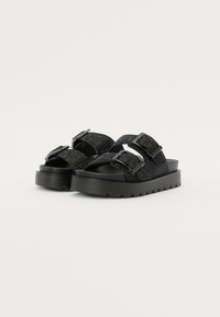 Svarte platå sandaler med to justerbare stropper, laget av teksturert materiale, med metalliske spenne detaljer og en tykk gummisåle.