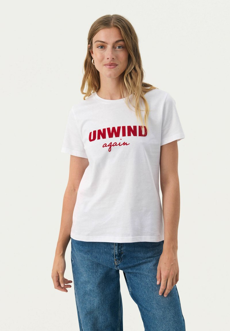 Witte katoenen shirt met rode tekst die "UNWIND" en "again" in een casual lettertype leest. Korte mouwen en standaard pasvorm.