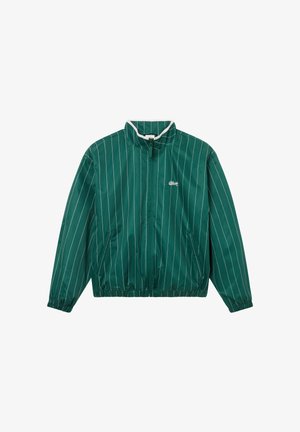 Chaqueta verde con cremallera y rayas verticales blancas, puños y dobladillo elásticos, y un pequeño logo blanco en el lado izquierdo del pecho.