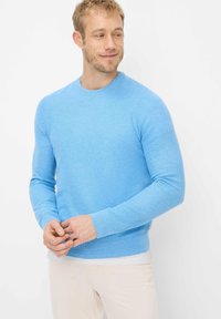 Lyseblå strikket sweater lavet af blødt stof, med rund hals, lange ærmer samt ribstrikkede kanter og linning.