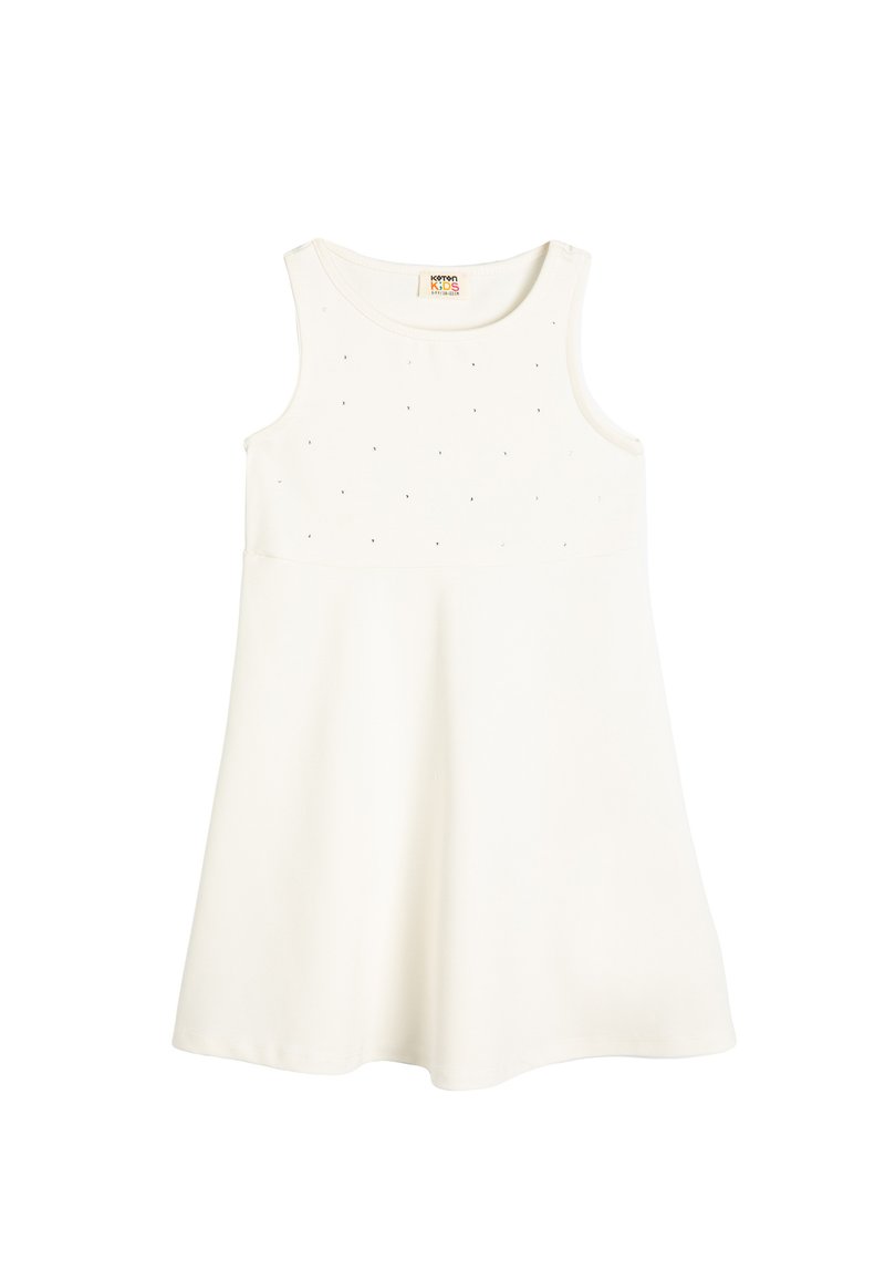 Vestido blanco sin mangas con una falda acampanada, hecho de una tela suave. El corpiño presenta pequeños y sutiles puntos decorativos.