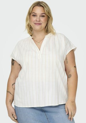 Chemisier blanc à manches courtes avec des rayures verticales orange, un décolleté en V et une coupe décontractée, associé à un jean en denim clair.