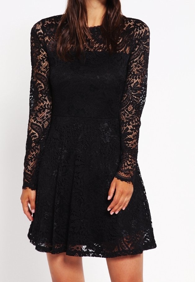 Vestido negro de encaje con mangas largas, un cuerpo ajustado y una falda acampanada. Presenta intrincados patrones florales y un escote redondo.