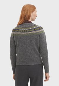 Pull en maille gris avec un empiècement en motif coloré dans des teintes de vert, bleu et violet. Les poignets et l'ourlet côtelés ajoutent de la texture et des détails.