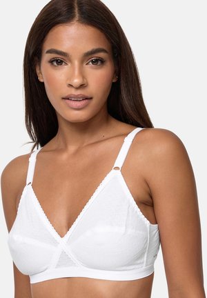 Kobieta ubrana w biały biustonosz miękki z regulowanymi ramiączkami, z delikatnym teksturowanym wzorem i głębokim dekoltem w kształcie litery V.