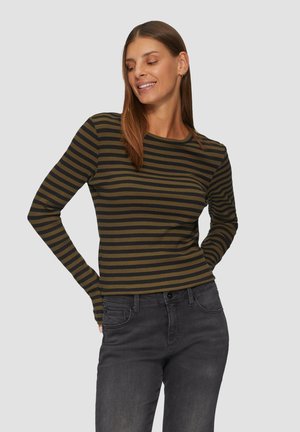 Langärmliges Rippenoberteil mit olivgrünen und schwarzen horizontalen Streifen. Mit Rundhalsausschnitt und figurbetontem Schnitt. Kombiniert mit dunkelblauen Jeans.