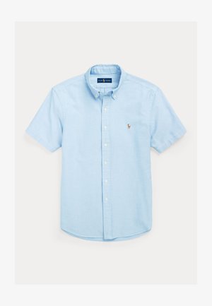 Šviesiai mėlyna trumpomis rankovėmis marškiniai su klasikiniu apykakliu, kairėje krūtinės pusėje su mažyčiu siuvinėtu logotipu ir tiesia apačia.