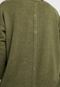 Cardigan in maglia verde oliva con finitura testurizzata, scollo rotondo e sette bottoni integrati sulla parte posteriore.