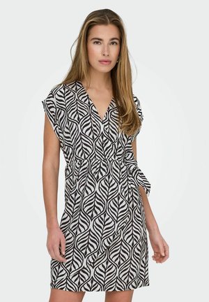Robe à manches courtes en noir et blanc avec un motif de feuilles, décolleté en V et taille élastique avec un accent noué. Texture du tissu lisse.